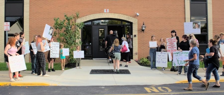 Protesters stand in front of middle school entrance before being told to move to the street curb.