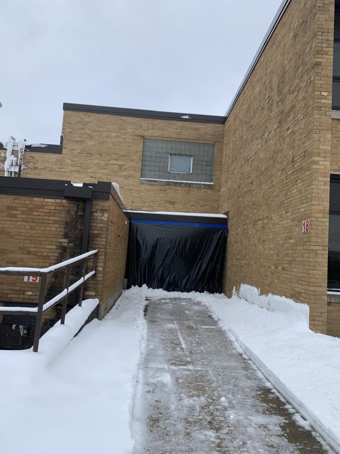 A barrier is placed on the exterior doors to the damaged area.