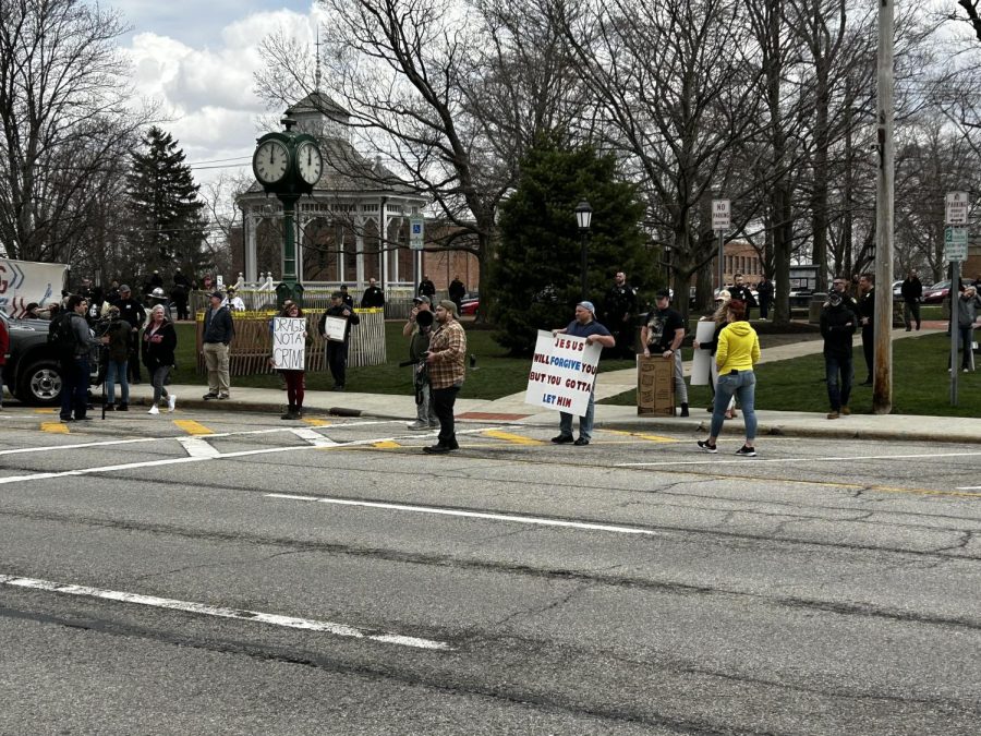 Opposition groups stand across the street from the restaurant. (Bob Rich)